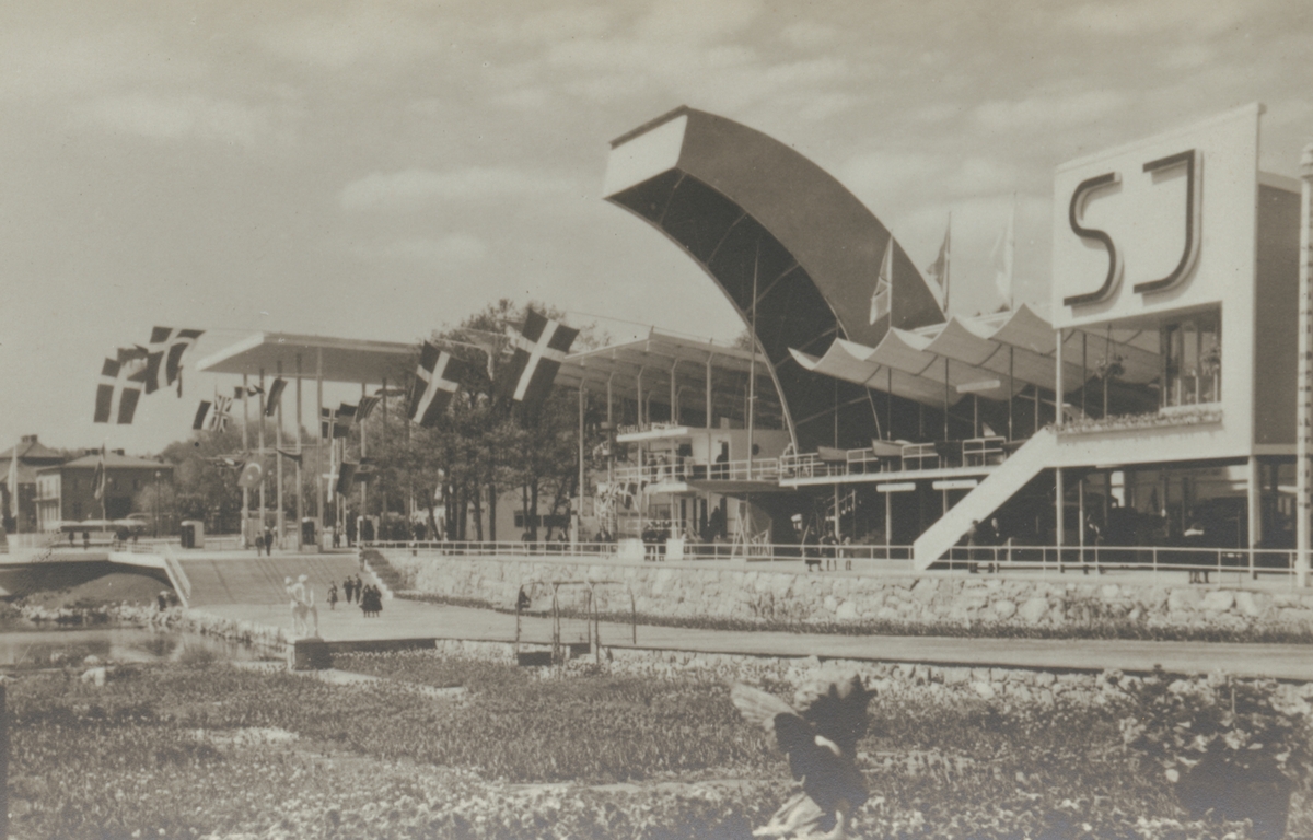 Fotografi från Stockholmsutställningen 1930. Motiv av Alnarpsträdgården och Samfärdshallen. Även en stor skylt med reklam för SJ.