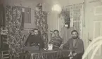 Bild från expedition i Antarktisområdet. Motiv av tre män som sitter inomhus vid ett bord, 1929.
