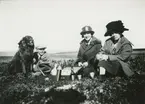Bild från expedition i Antarktisområdet. Motiv av två kvinnor, en pojke och en hund som har picnic.