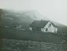 Fotografi från Grönland. Motiv av hus i bergslandskap.