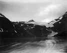 Fotografi från Nordkalotten. Motiv av hav och snötäckt berg.