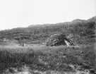 Fotografi från Eldslandet. Motiv av hydda i gräsbevuxet bergslandskap.