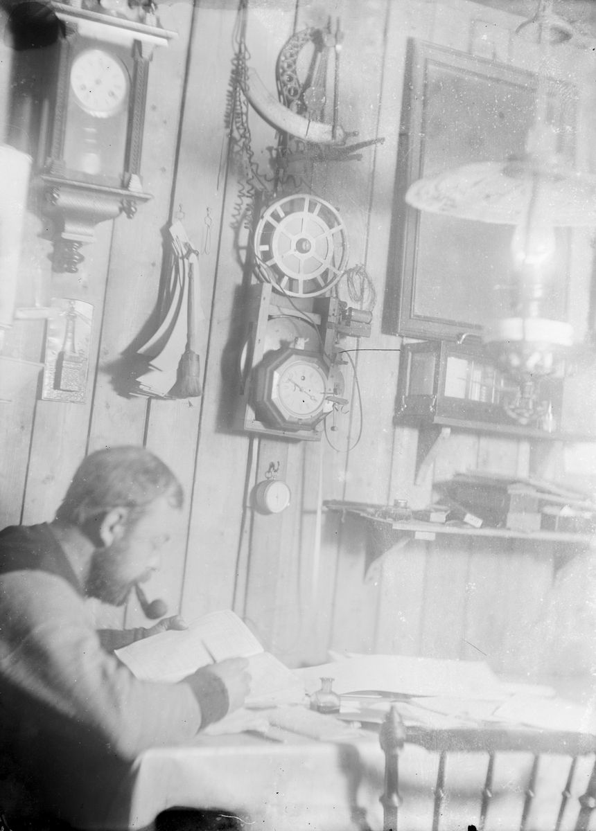 Fotografi från undsättningsexpeditionen med fartyget Uruguay 1903. Motiv av man med pipa inomhus.