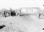 Fotografi från undsättningsexpeditionen med fartyget Uruguay 1903. Motiv av kvinna och barn vid litet hus.