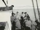 Fotografi från svenska undsättningsexpeditionen 1928. Motiv av en grupp män ombord på fratyget 