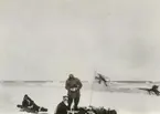 Fotografi från svenska undsättningsexpeditionen 1928. Motiv av tre män som vilar i snön i Murchison Bay. Från vänster: Christell, Rosensvärd, Jacobsson.