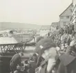 Fotografi från Albin Ahrenbergs resa till Grönland 1929. Motiv av stor samling människor vid flygbåt i stad.