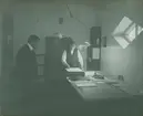 Fotografi från expedition till Spetsbergen. Motiv av två män i kontorsrum.