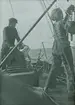 Fotografi från expedition till Spetsbergen 1920. Motiv av man och kvinna ombord på båt.