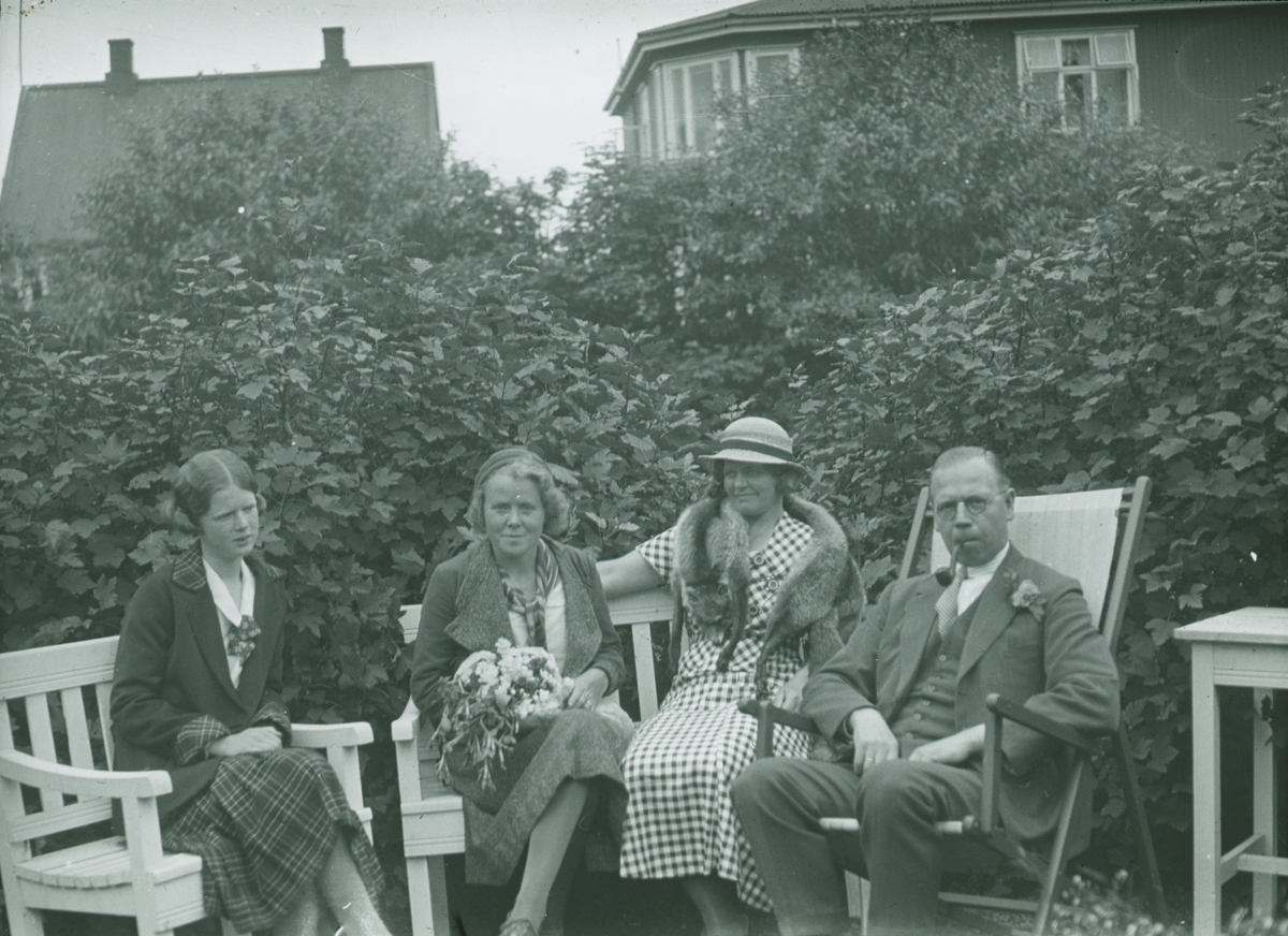 Fotografi från expedition till Spetsbergen. Motiv av familj som sitter framför buskar.