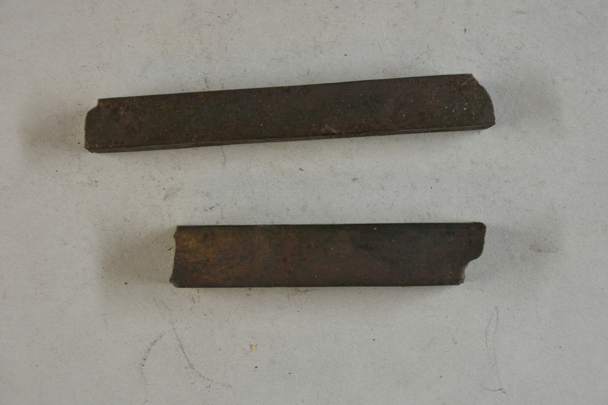 Två prov på garvat stål. Två tillhörande lappar med notering: "Garvat stål. Tillverkat vid Storfors i Kroppa socken, Värmland." och "Garvat stål fr. Storfors i Kroppa Sn i Wermland."