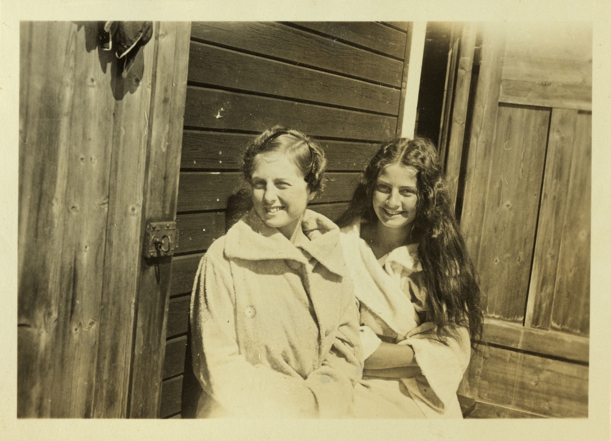 Mimi og Lucy Egeberg, iført badekåper, ved badehus, muligens på Snarøya. Fotografert juli 1926.