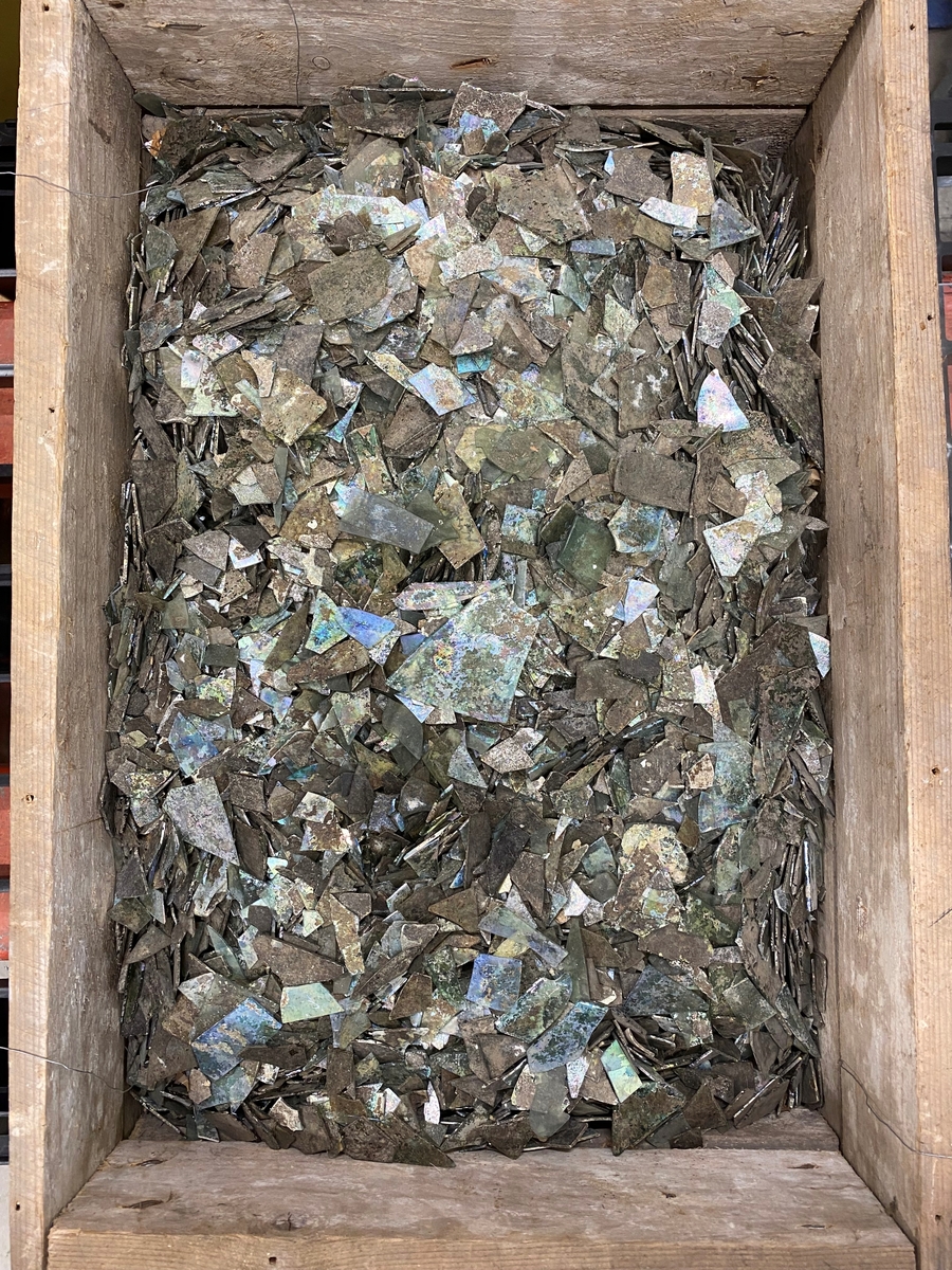 Totalt 39671 fönsterglasskärvor i varierande grad av grön glasmassa. Många kraftigt iriserande och sönderfallande av glassjuka. Flertalet av skärvorna är mycket fragmenterade, men ett antal fönsterglasformer med bearbetade kanter går att urskilja. Exempel av dessa är utplockade med nya fyndnummer, men med samma fältfyndnummer som M 17000-3135. Se relaterade objekt.