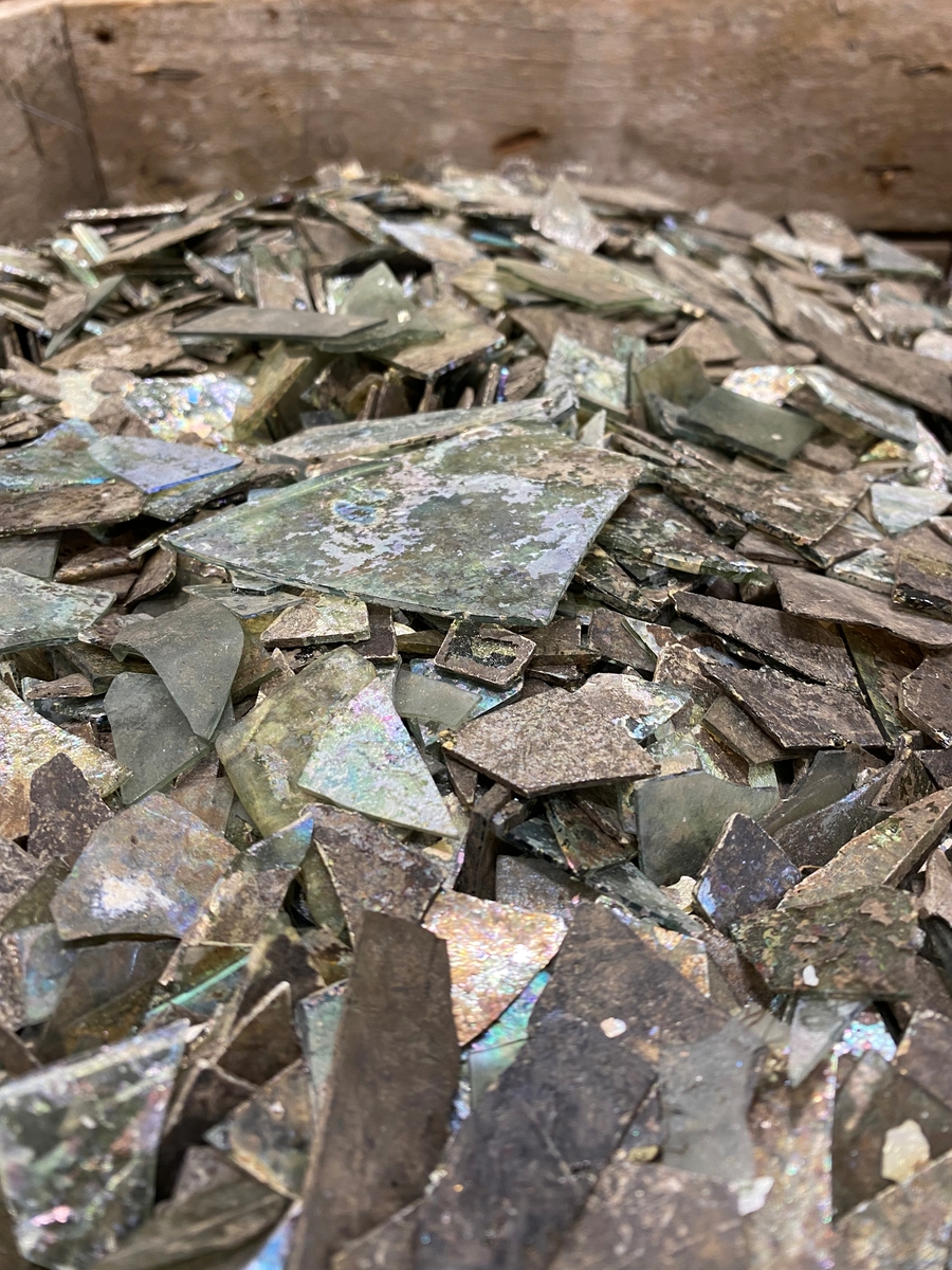 Totalt 39671 fönsterglasskärvor i varierande grad av grön glasmassa. Många kraftigt iriserande och sönderfallande av glassjuka. Flertalet av skärvorna är mycket fragmenterade, men ett antal fönsterglasformer med bearbetade kanter går att urskilja. Exempel av dessa är utplockade med nya fyndnummer, men med samma fältfyndnummer som M 17000-3135. Se relaterade objekt.