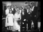 Bröllopsporträtt. Julia Westergren i bakgrunden bakom brudparet och Birger Westergren längst till höger i bild.