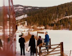Reisende stiger av persontog til Rødberg ved en planovergang