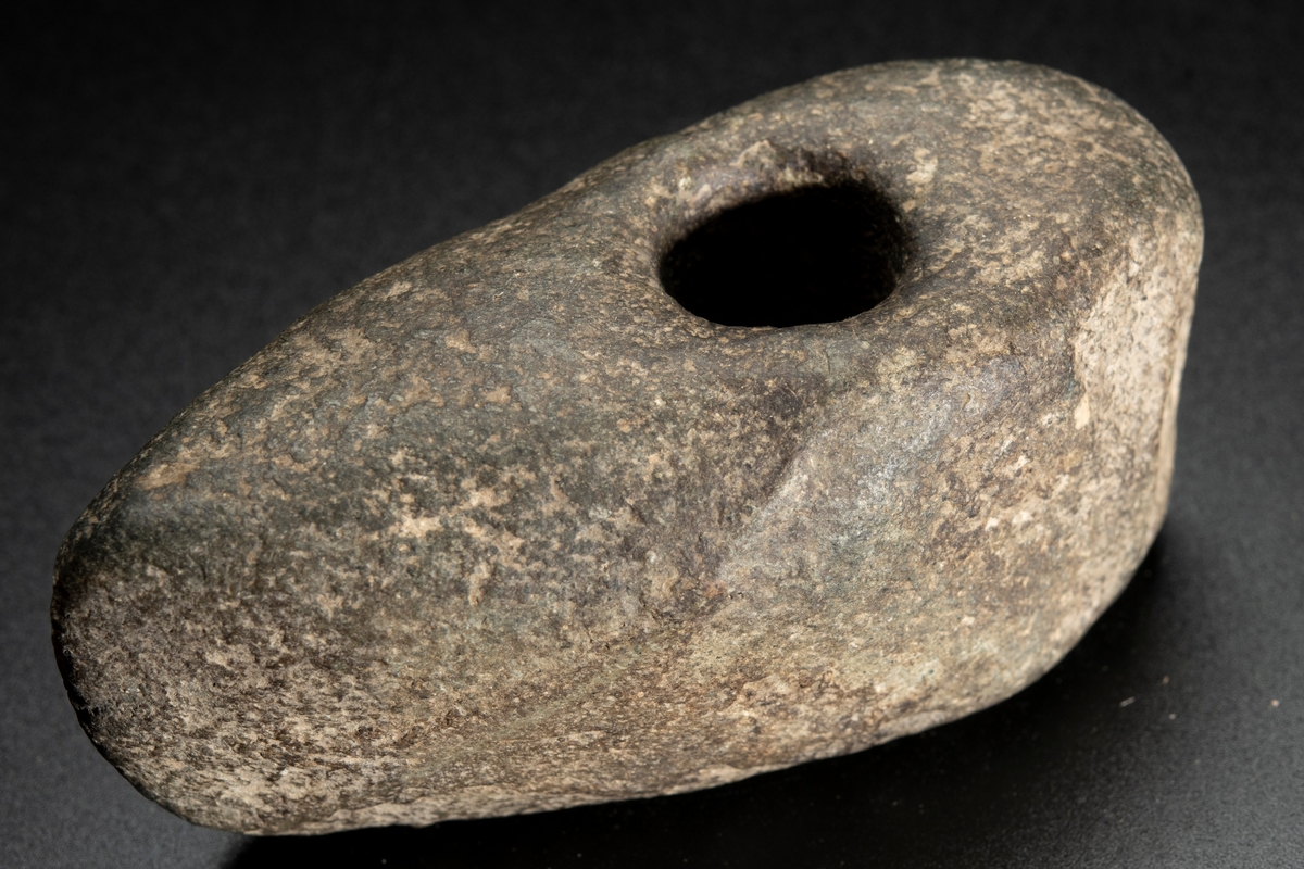 Skafthålsyxa av finkornig grönsten. Oregelbunden. Höga smalsidor.