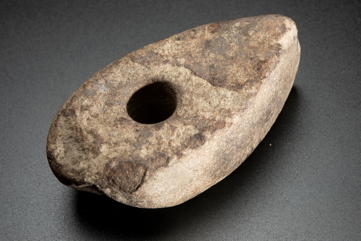 Skafthålsyxa av finkornig bergart (grönsten). Plana ytor. Välslipad. Nackpartiet oregelbundet.