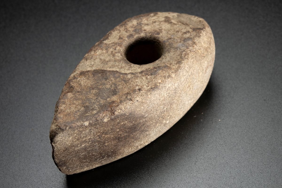 Skafthålsyxa av finkornig bergart (grönsten). Plana ytor. Välslipad. Nackpartiet oregelbundet.