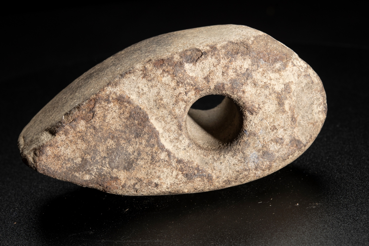 Skafthålsyxa av finkornig bergart (grönsten). Plana ytor. Välslipad. Nackpartiet oregelbundet.