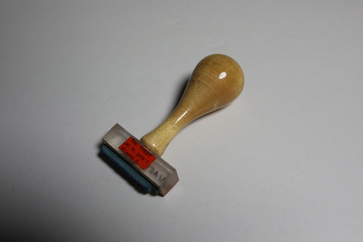 Gummistempel på rektangulært stempelhodet som er gjennomsiktig og man kan da lese hva som står under stempelet. I midten på toppen er håndtaket festet. Håndtaket smalner først svakt inn før det  vider seg ut mot den runde toppen som gir det et pæreformet form.