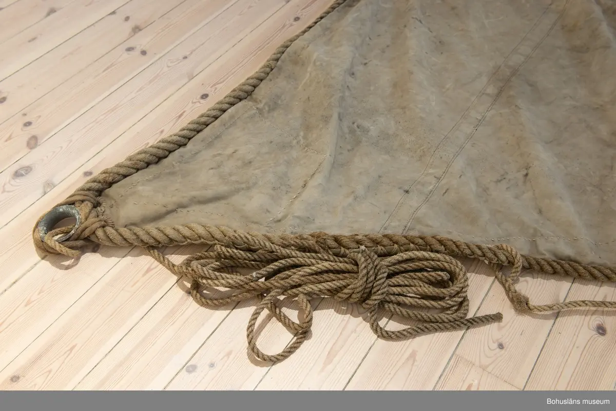 Segel Av kraftig obarkad segelduk av linne. Samtliga sidor - lik - förstärkta med tågvirke. 
Målade beteckningen SD 326 i svart. (Strömstad). 
Seglet är omsytt av ett tidigare storsegel till vanlig fiskebåt, arbetet utfört av segelmakare.