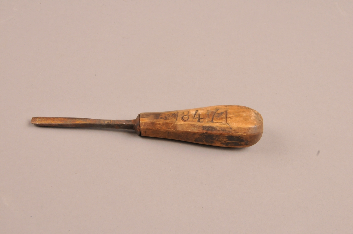 Treskjærerjern med rund egg. Spikka skaft med innskåret årstall: 1847.
