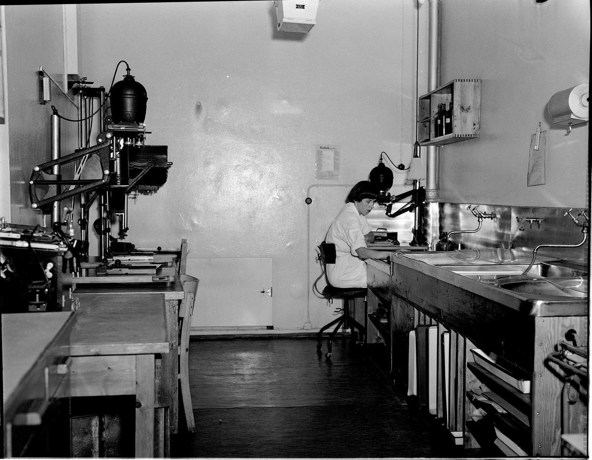 En kvinnelig laborant i hvit frakk i arbeid på Kriminallaboratoriet.