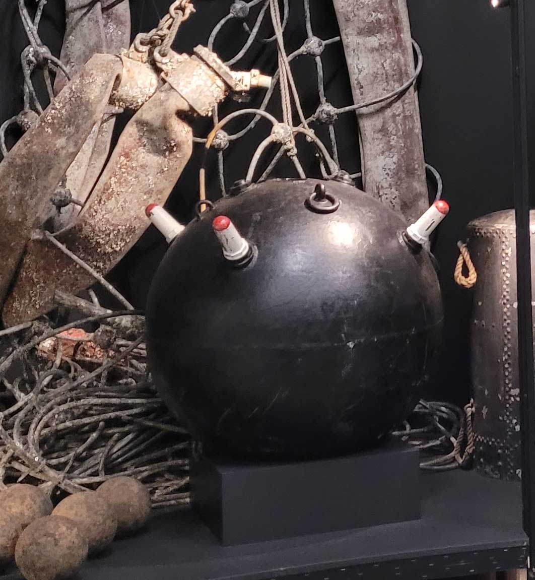 HORNMINA modell F4. Svart, hornskydden vita och röda. Sfärisk form med fyra horn.