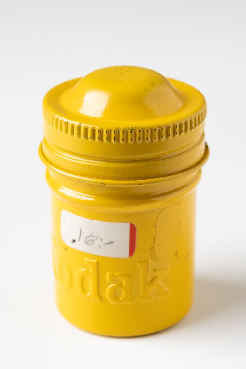Burk med skruvlock, av aluminiumplåt. Rund, gulfärgad med texten "KODAK" i relief. Sekundärt påklistrad prislapp med påskrivet pris: "16 :-". Burk avsedd för rullfilm (stillbilder).

Se vidare Historik