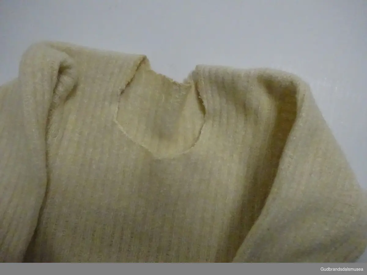 Nattskjorte -  strikket. Bøtt sammen av flere plagg for å øke størrelsen eller for å spare garn. Skjøta i et stort stykke både på bryst og rygg.  Hjemmespunnet tynt garn.