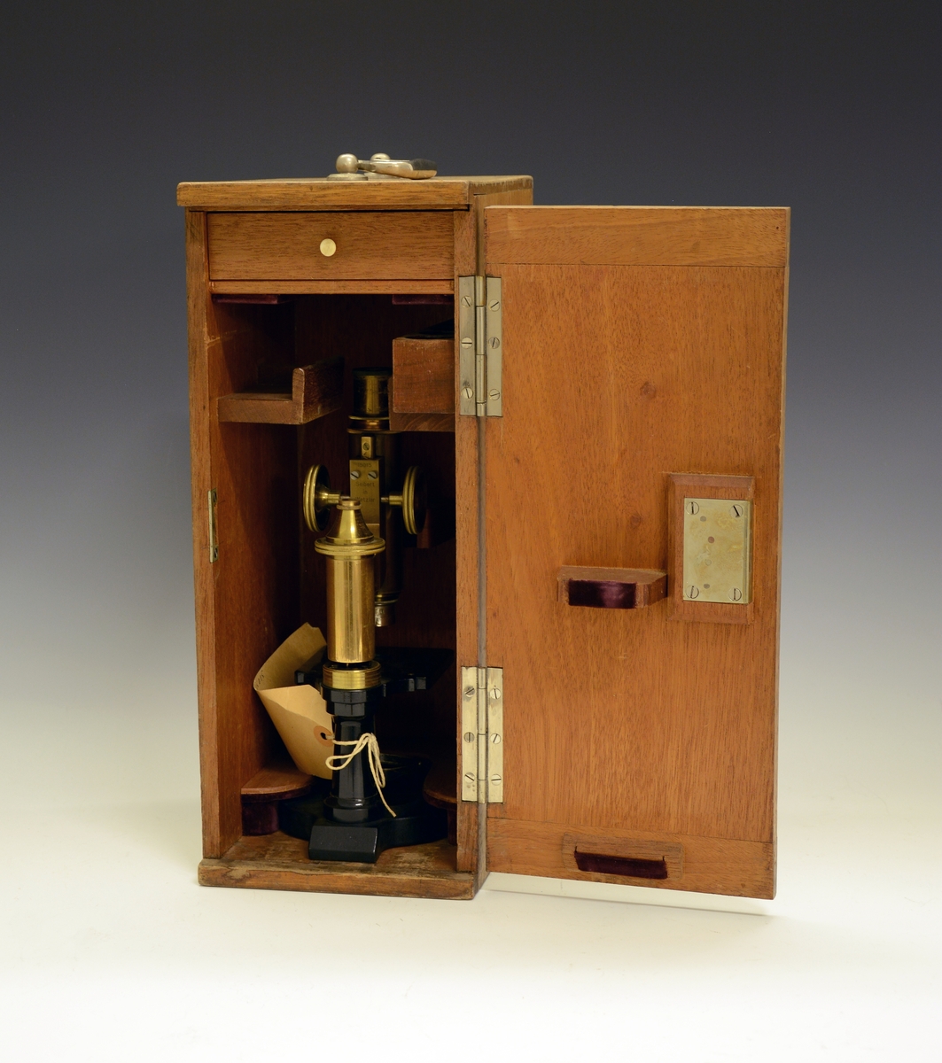 Mikroskop i kasse. Fra protokollen: Treetui med mikroskop. Etuiet er låsbart og har bærehåndtak øverst. Mikroskopet er av messing og sort lakkert metall, av merket Seibert in Wetzlar. Merket 15015 (serienummer), montert med linse merket 3.