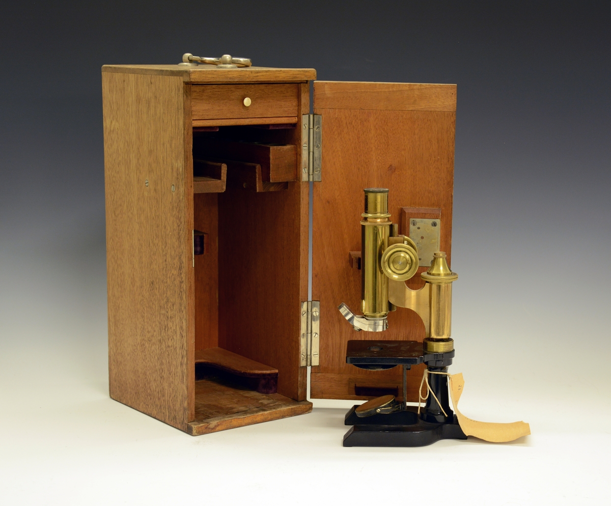 Mikroskop i kasse. Fra protokollen: Treetui med mikroskop. Etuiet er låsbart og har bærehåndtak øverst. Mikroskopet er av messing og sort lakkert metall, av merket Seibert in Wetzlar. Merket 15015 (serienummer), montert med linse merket 3.