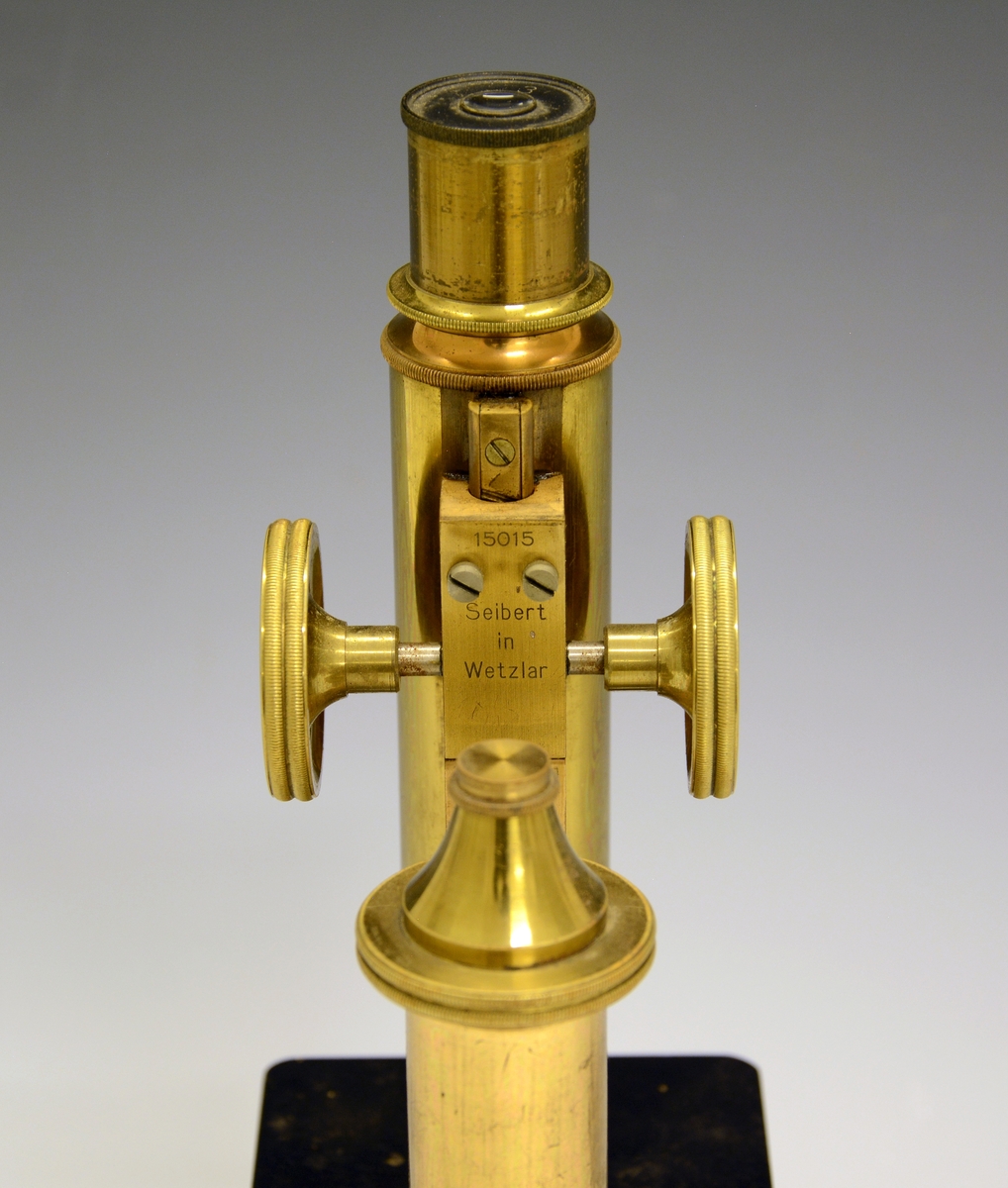 Mikroskop i kasse. Fra protokollen: Treetui med mikroskop. Etuiet er låsbart og har bærehåndtak øverst. Mikroskopet er av messing og sort lakkert metall, av merket Seibert in Wetzlar. Merket 15015 (serienummer), montert med linse merket 3.