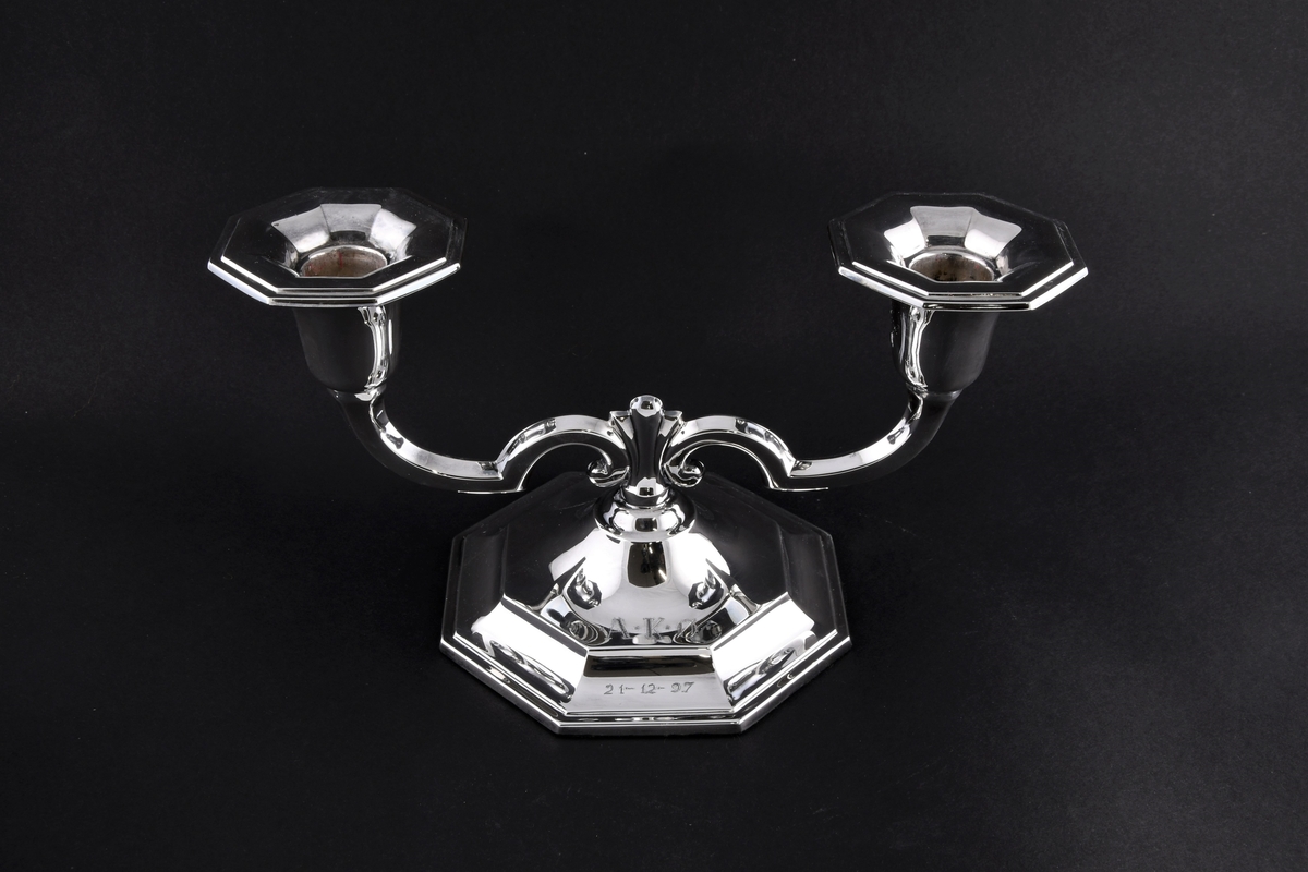 Lysestake med to armer og åtte-kantet fot.