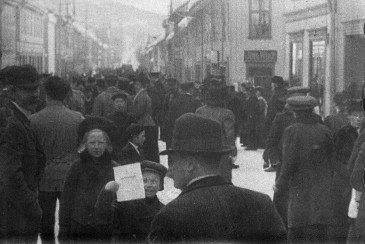 Stillbilde fra Albert Hougners film fra Storgata, Lillehammer 1912. Bildet er tatt sørover med Friesenberg og Belsvik på høyre side. På Belsvik-/Baadshaug-gården er et skilt med "Joh. Wike"