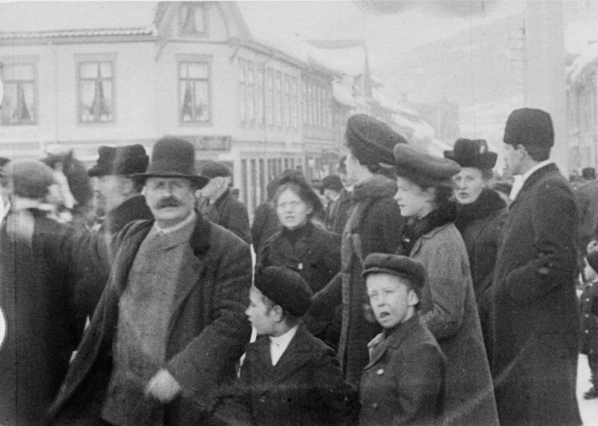 Stillbilde fra Albert Hougners film fra Storgata, Lillehammer 1912. Menneskemengde ved Lilletorget, med forretningen til Gustav Kapelrud i bakgrunnen