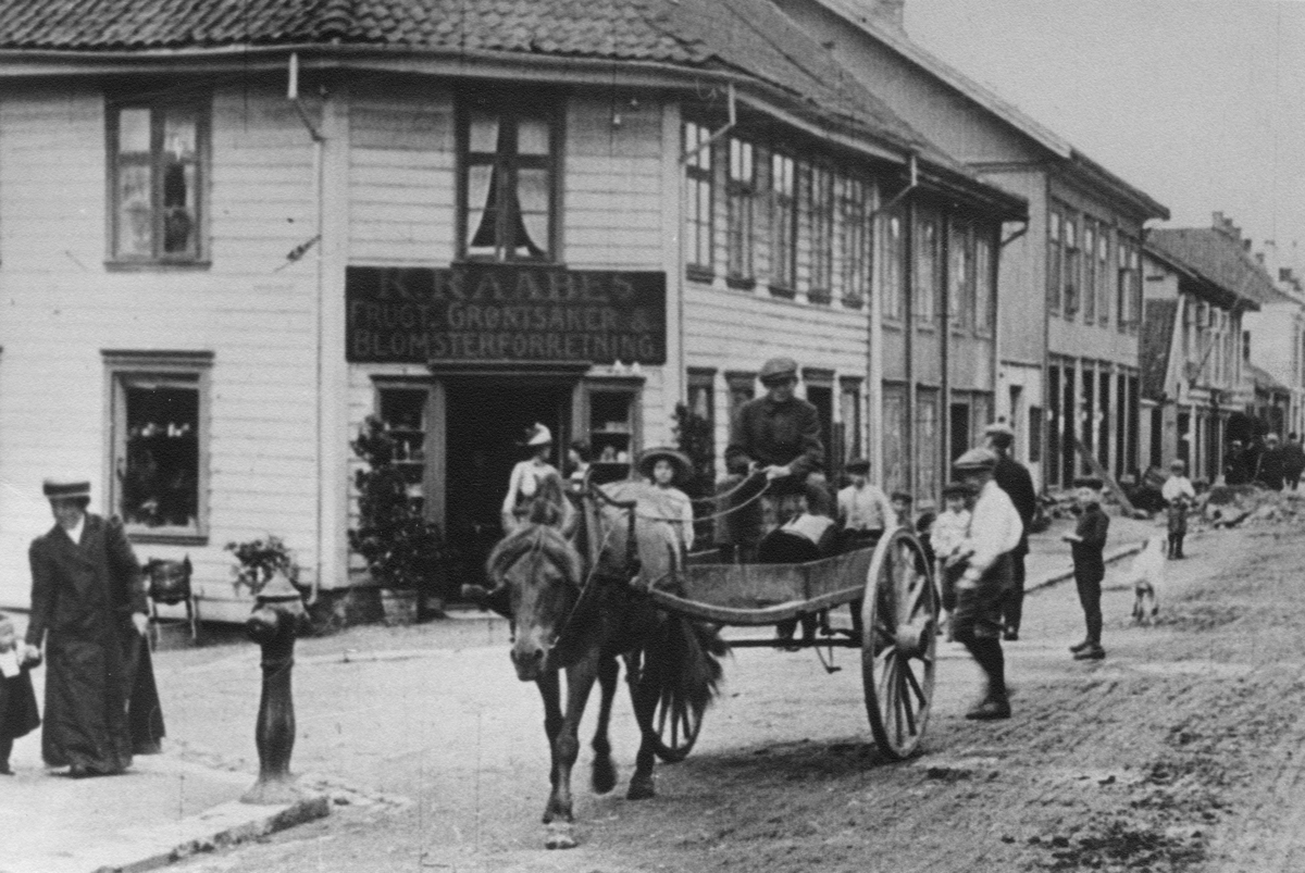 Stillbilde fra Albert Hougners film fra Storgata, Lillehammer 1912. Storgata 46, Raabe-hjørnet, til venstre. Et av de eldste husene i byen med hjelpefengsel i bakgården.