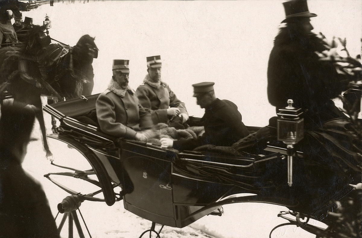 Gustav V:s besök (tillsammans med kronprins Gustav Adolf) i Växjö 1913.
Man har tagit plats tillsammans med landshövdingen i en vagn (apterad till släde) som var utlånad av greve Posse
på Bergkvara.