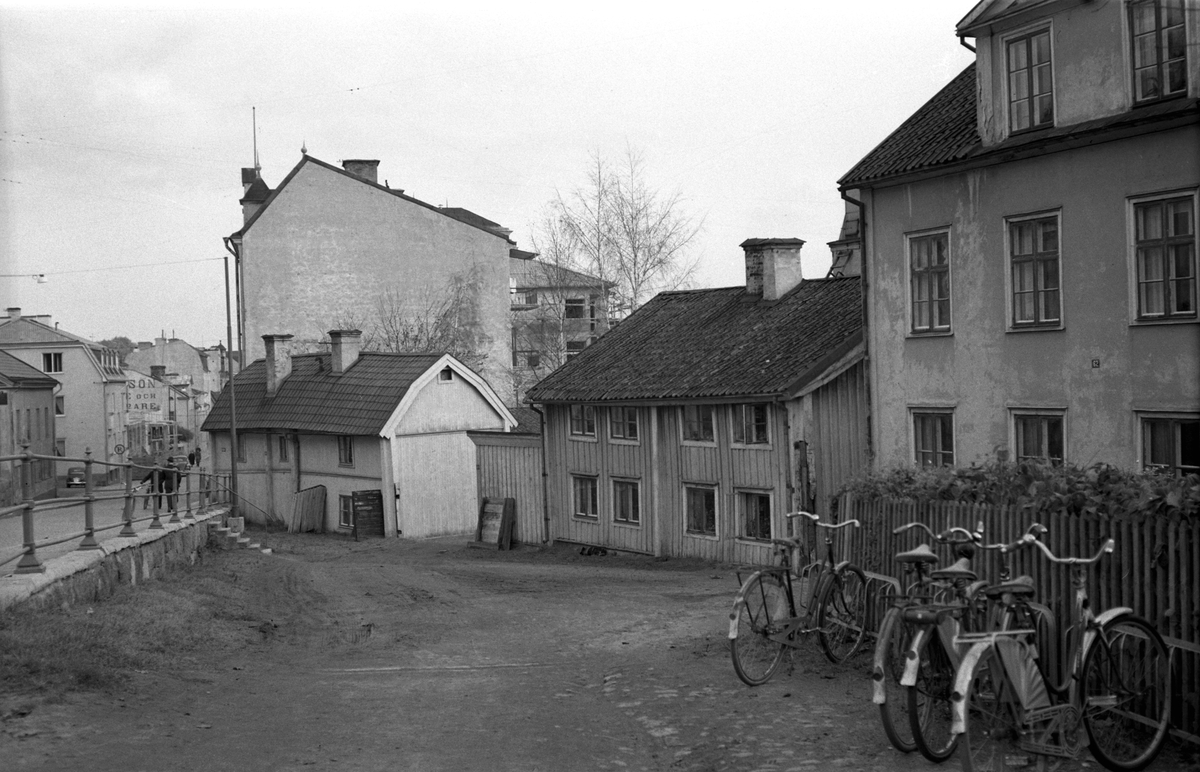 Fram till tiden omkring invigningen av Rally motell 1960, hade Nygatan sitt löp fram till korsningen med Storgatan-Barnhemsgatan. Gatans västliga ände, Nygatsbacken, lades ut först under 1860-talet och skar då av den här vindlande Sankt Korsgatan, vilket förklarar de äldre husens vinkelställda läge. Det bägge nedre, äldre husen har upplysningsvis flyttats till friluftsmuseet Gamla Linköping som Systrarna Petterssons gård respektive Anderska gården. Bilden kan utifrån särdrag dateras till 1954.