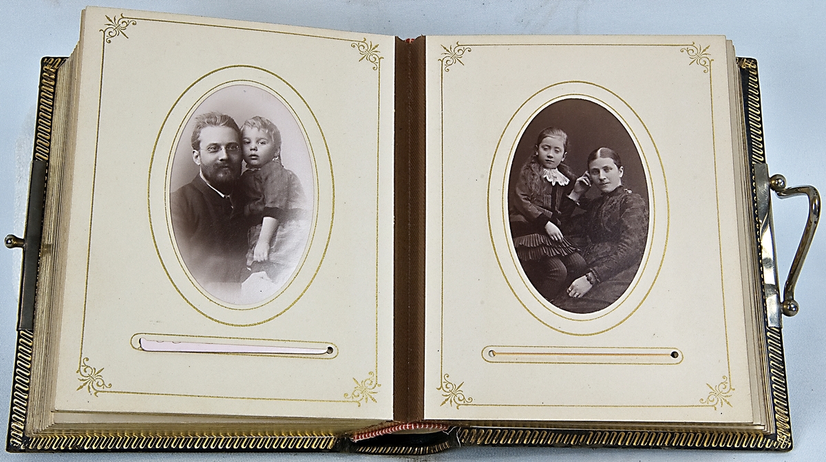 Fotoalbum, i svart papp. Dekor med gyllene ornamentik och plåtmedaljong samt lås. Albumet har tillhört Gustaf Swedlund.