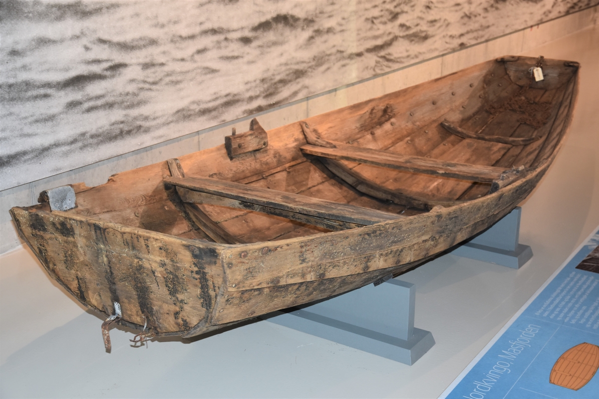 Pram (ferje) med eit par keiper. Jernsaum. To tofter - ei laus og ei fast. Kjetting og tau er festa på innsida framme. Restar av metallband festa i underkant utvendig framme og bak. Prammen er rettskoren framme og bak. Klinkbygd, tre bord.