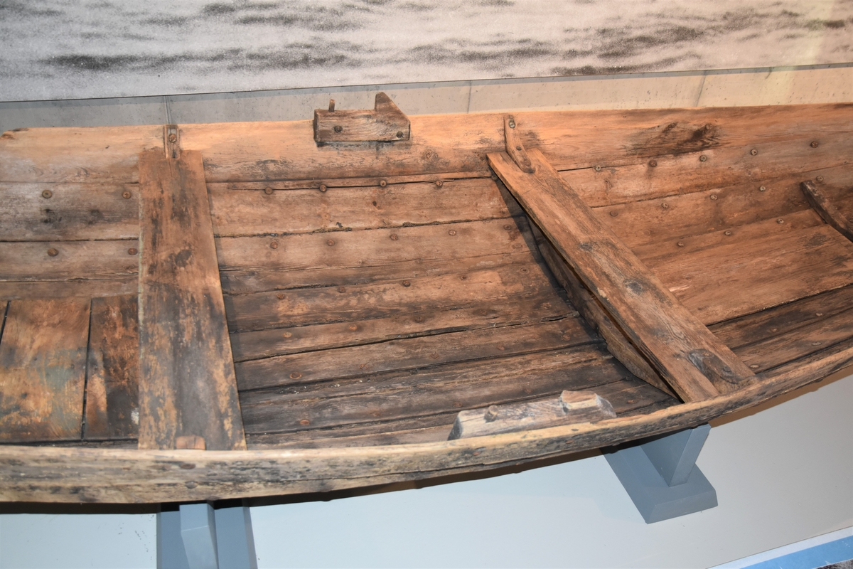 Pram (ferje) med eit par keiper. Jernsaum. To tofter - ei laus og ei fast. Kjetting og tau er festa på innsida framme. Restar av metallband festa i underkant utvendig framme og bak. Prammen er rettskoren framme og bak. Klinkbygd, tre bord.