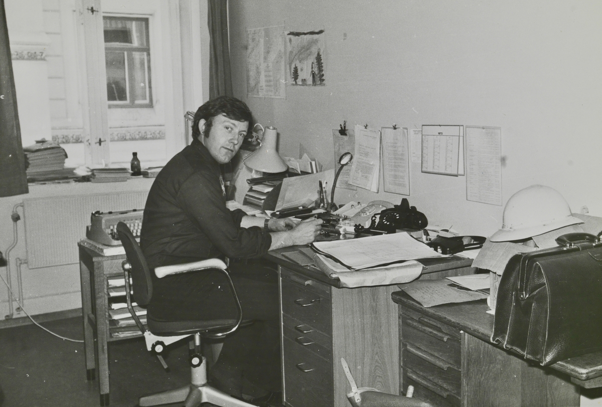 En mann sitter ved et skrivebord.