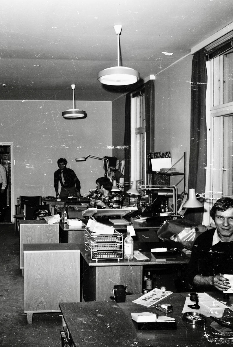 Kontorlandskap med ansatte i arbeid, både kvinner og menn.