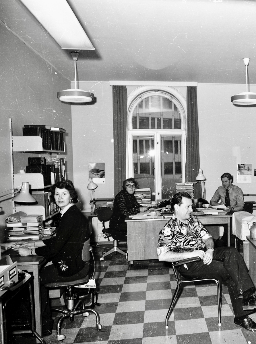 Kontorlandskap med ansatte i arbeid, både kvinner og menn.