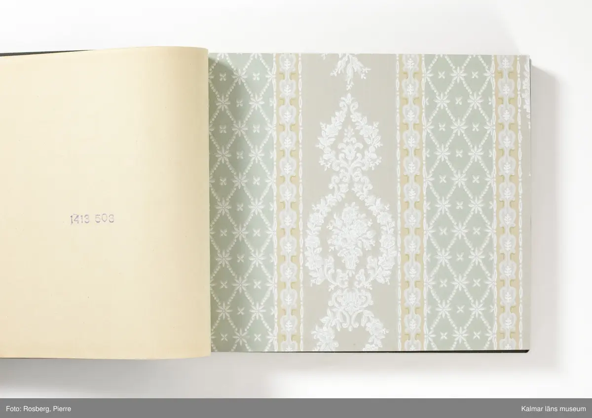 KLM 46599:3. Tapetkatalog. Katalog med pärm av grön papp eller kartong. Bunden med hjälp av tre metallnitar. Text i silver på pärmens framsida: EMMABODA TAPETFABRIK AB Emmaboda. Katalogen innehåller en mängd olika plastförstärkta tapetprover tillverkade av papper, med olika strukturer, färger och mönster, moderna under 1950 och 1960-talen.