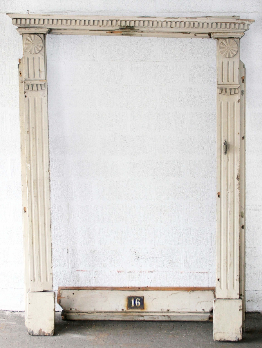 Pilastrar med räfflor, överst cirkelrund dekor, nedanför denna list med tandsnitt. Krönlist med tandsnitt. Därunder slätt parti med husnumret "16" i vitt på blå emalj. Under siffrorna fönster, grönmålat med oregelbunden ruta i mitten, på vardera sidan 3 rutor med skuret kryss. Under fönstret tandsnittsbård. Tröskel.

Hör till dubbeldörr BM 64754. Teckning på det gamla registerkortet.

Proveniens: Från ett rivet hus (1965) på Lilla Brogatan 16, Borås.