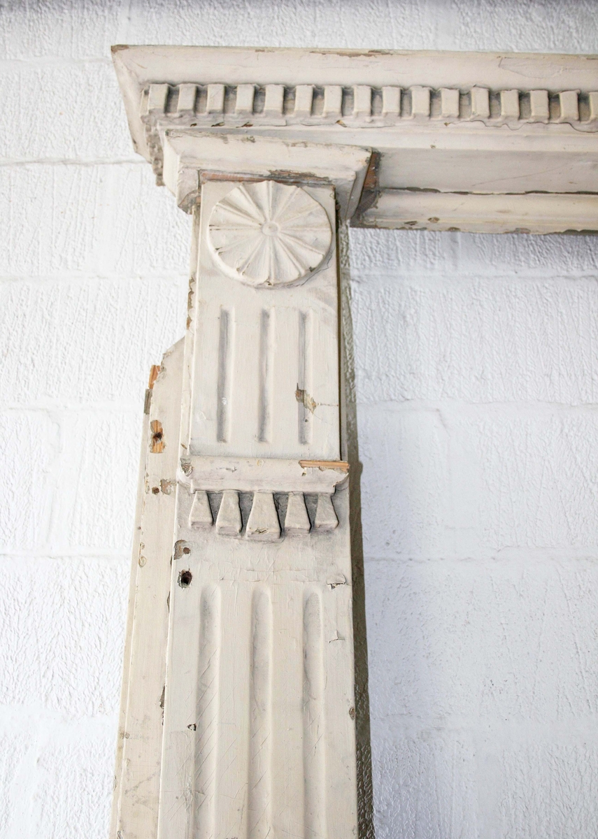 Pilastrar med räfflor, överst cirkelrund dekor, nedanför denna list med tandsnitt. Krönlist med tandsnitt. Därunder slätt parti med husnumret "16" i vitt på blå emalj. Under siffrorna fönster, grönmålat med oregelbunden ruta i mitten, på vardera sidan 3 rutor med skuret kryss. Under fönstret tandsnittsbård. Tröskel.

Hör till dubbeldörr BM 64754. Teckning på det gamla registerkortet.

Proveniens: Från ett rivet hus (1965) på Lilla Brogatan 16, Borås.