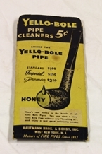 Piperenseetui. Papp. Rektangulær. Gul bakgrunn. Mye skrift i sort. Illustr. pipe på den ene siden, rensemiddelflaske på den andre siden. Inneholder to hvite piperensere.
